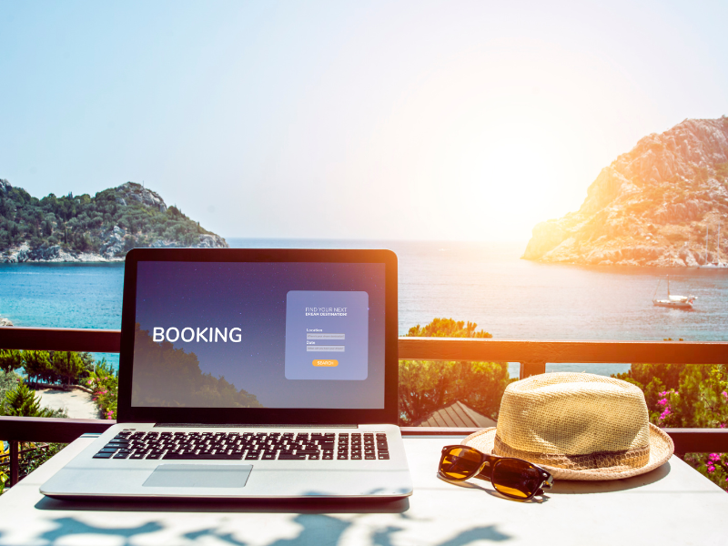 Ordenador portátil con una web de reservas frente al mar, simbolizando la digitalización de negocios náuticos.
