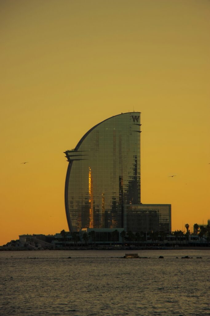 Vista del Hotel W Barcelona al atardecer desde el mar, representando la sede de Caretta Marketing Náutico y su conexión con el entorno costero.